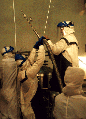 Workers in cleanroom suits servicing SHOOT.